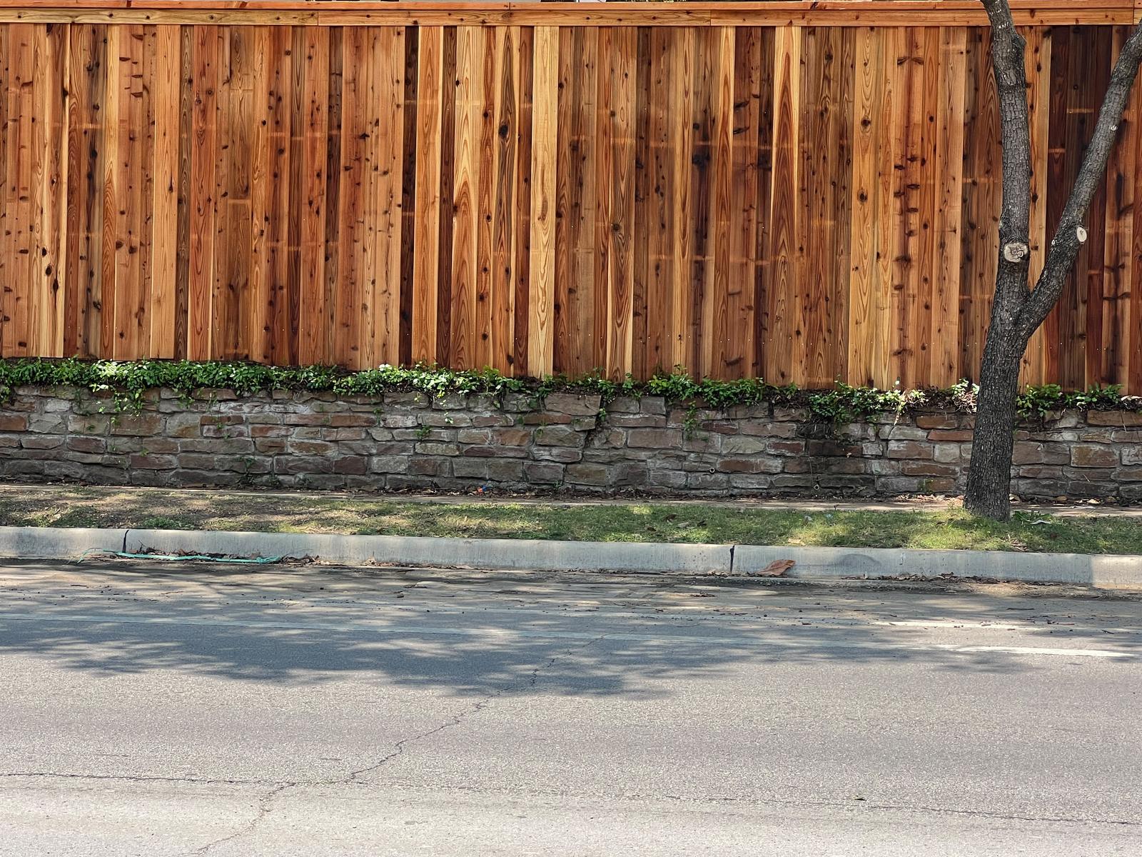 Cedar cap-rail fence on a stone retaining wall