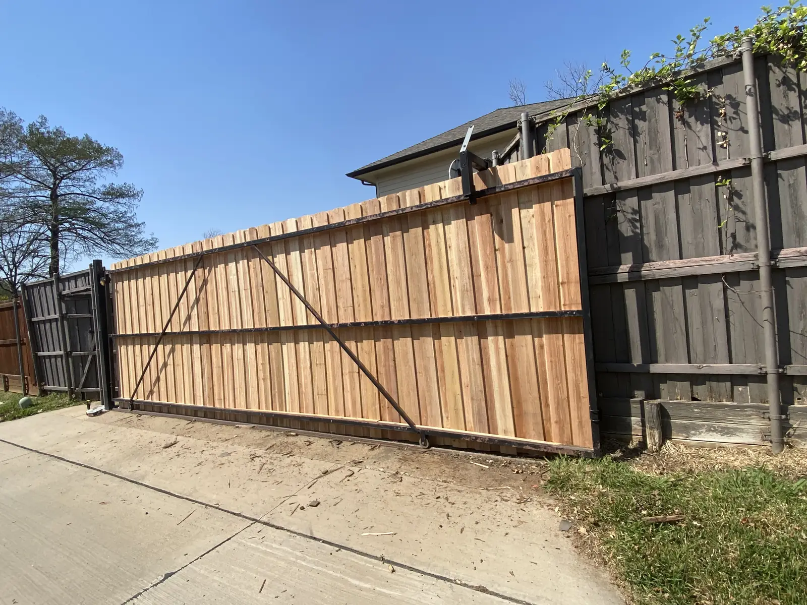 Rolling driveway gate clad in fresh cedar on a steel frame