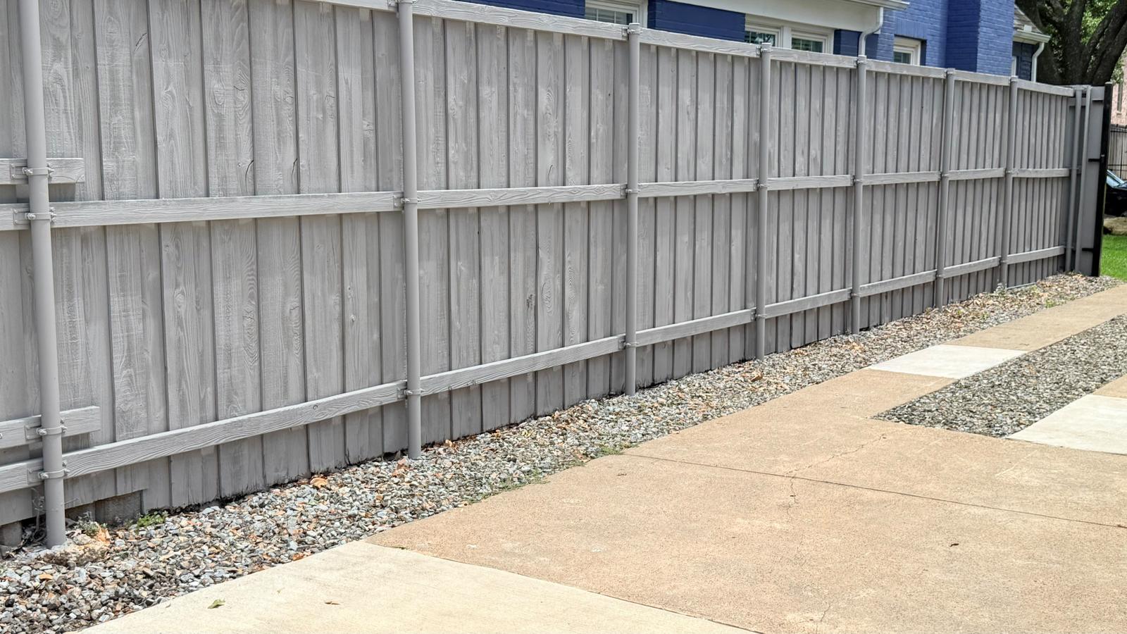 Painted board-on-board fence along a sidewalk