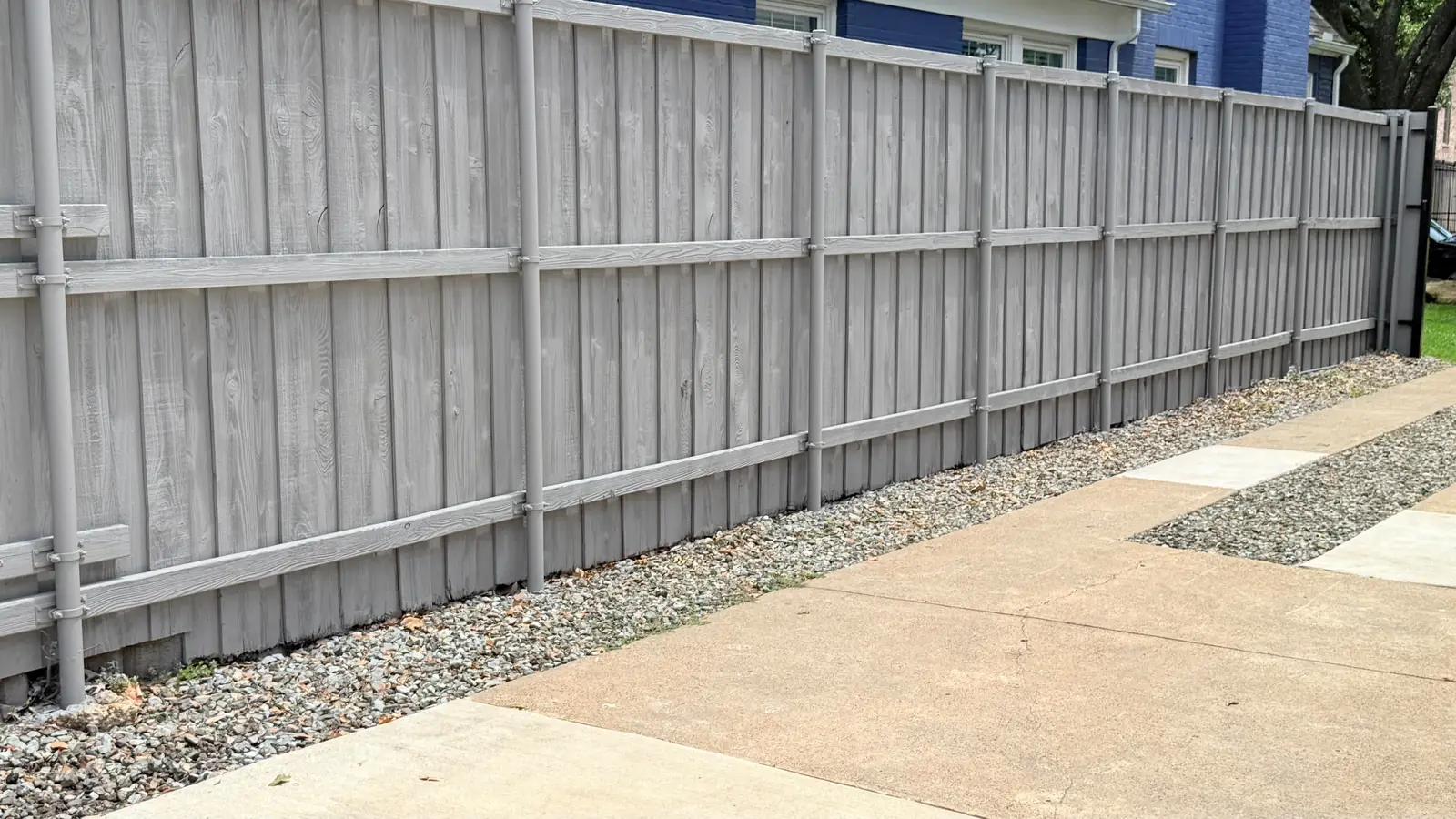 Painted board-on-board fence along a sidewalk