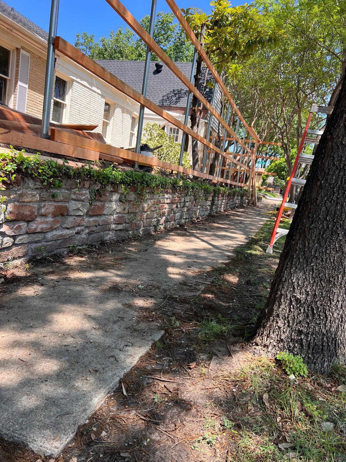 Steel posts and cedar rails framed over a brick retaining wall
