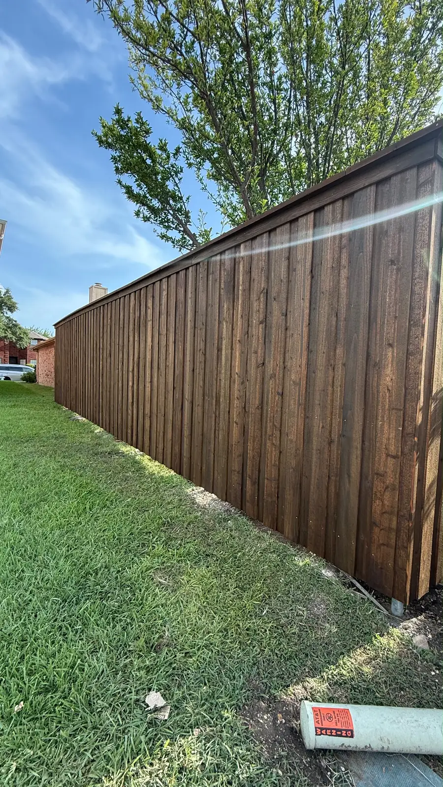 Finished dark-stained 8-foot board-on-board fence