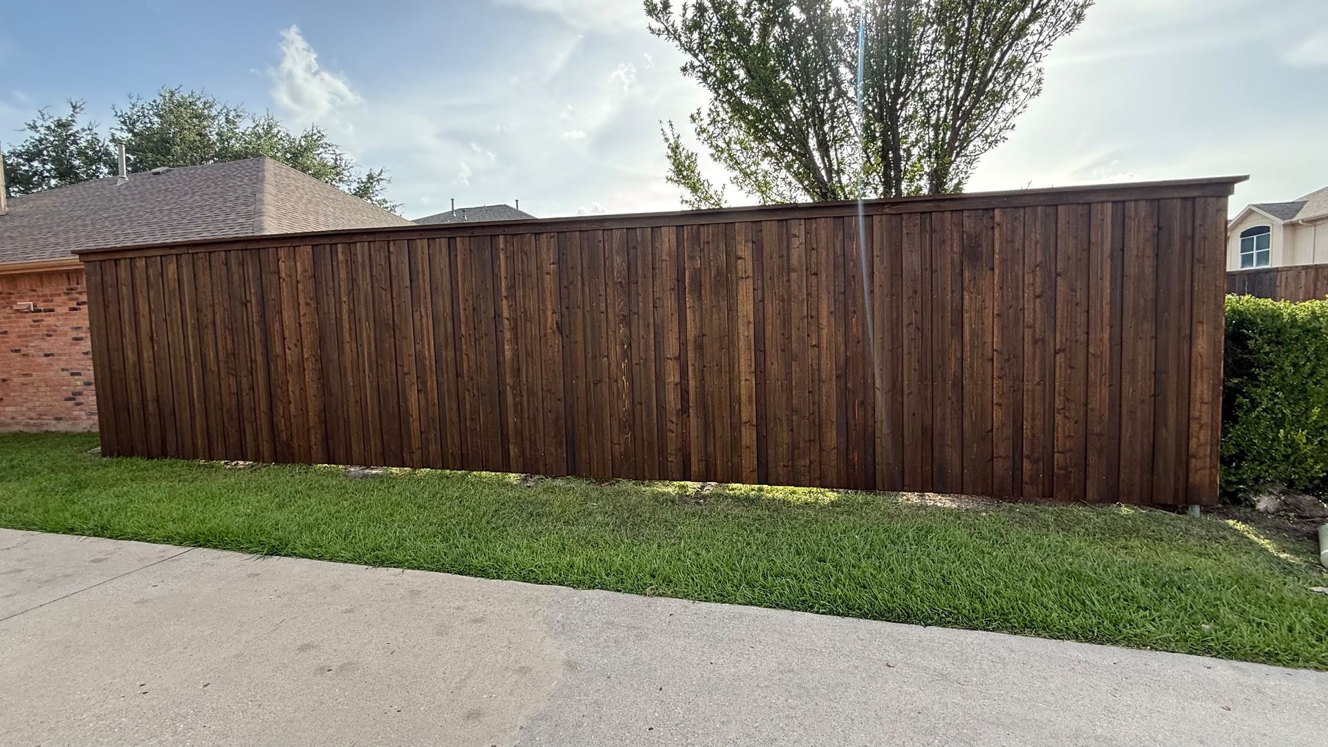 Dark-stained board-on-board privacy fence built by Menera Brothers