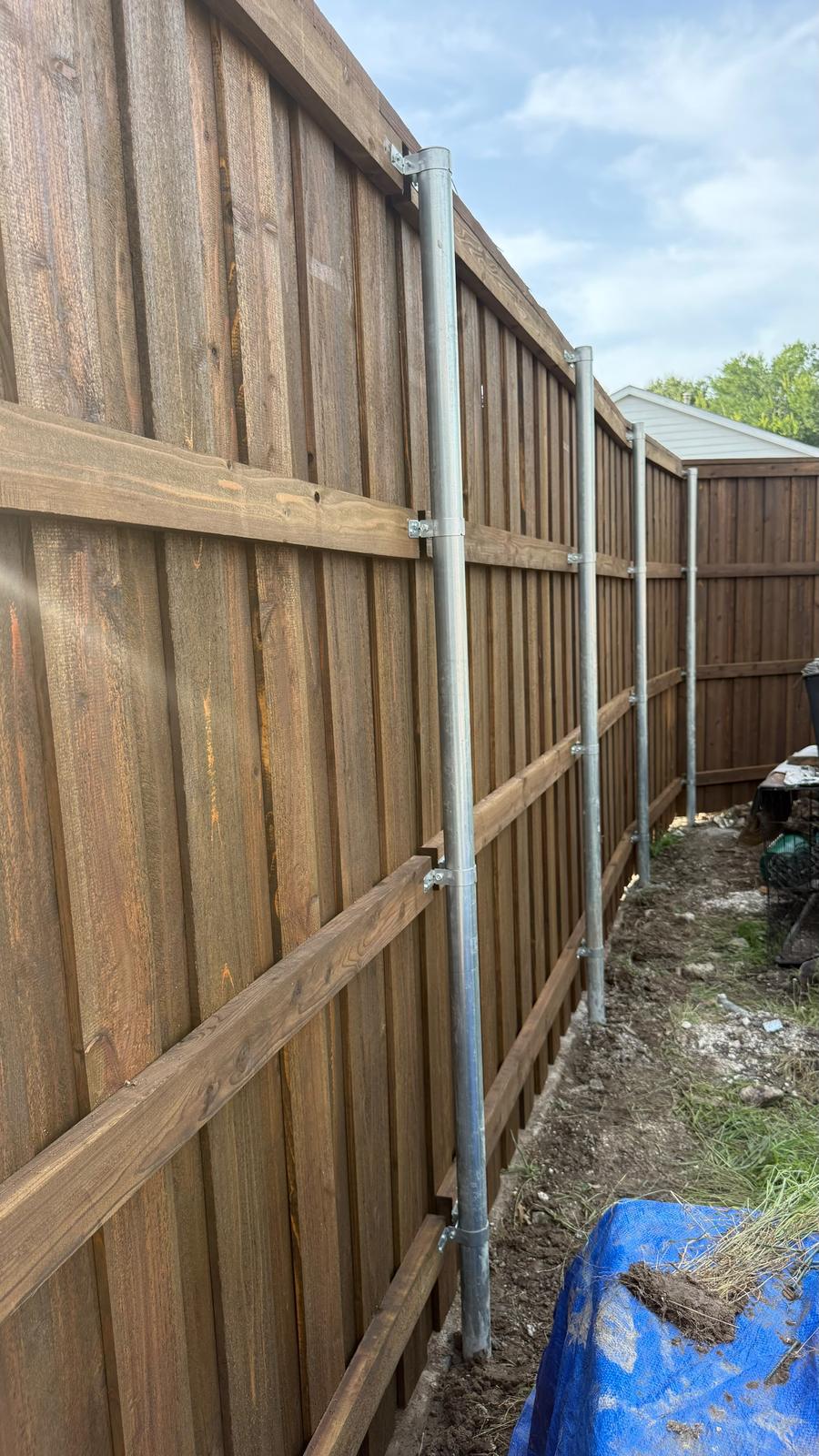 Galvanized steel fence posts set in concrete